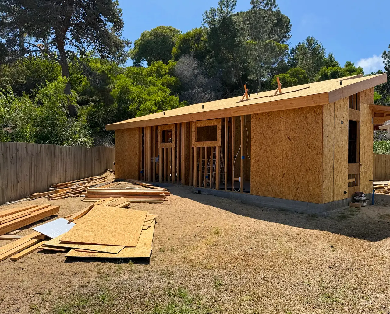 Side of the detached ADU with the roof sheathed and the walls framed and partly sheathed