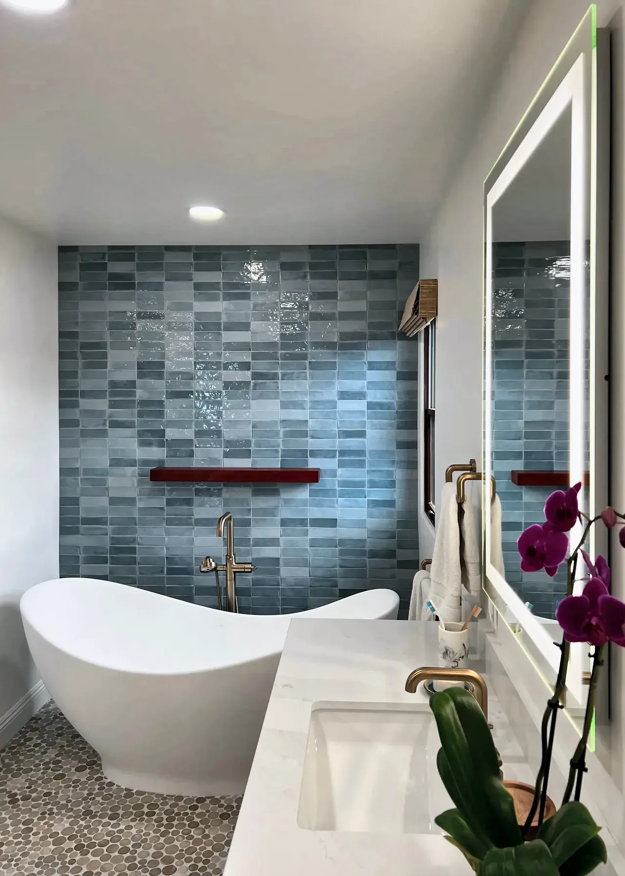Blue tile feature wall behind a freestanding tub