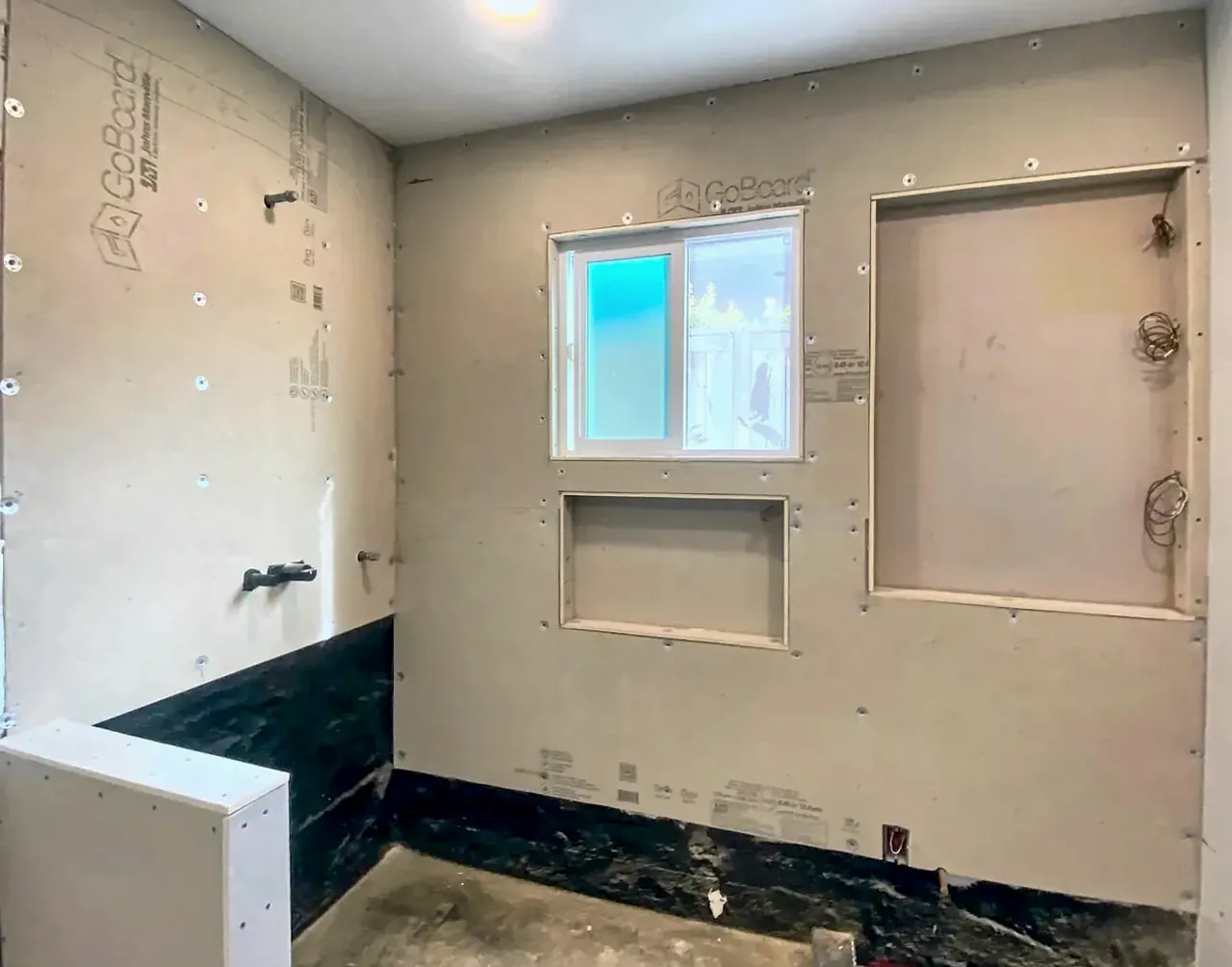A Del Mar shower at the backer-board stage, with the window, niche and tall niche openings framed before tile
