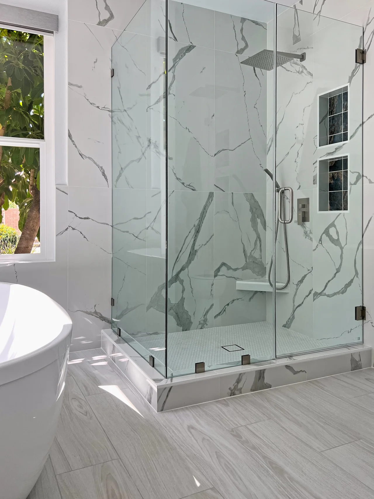 Frameless glass shower in marble-look tile