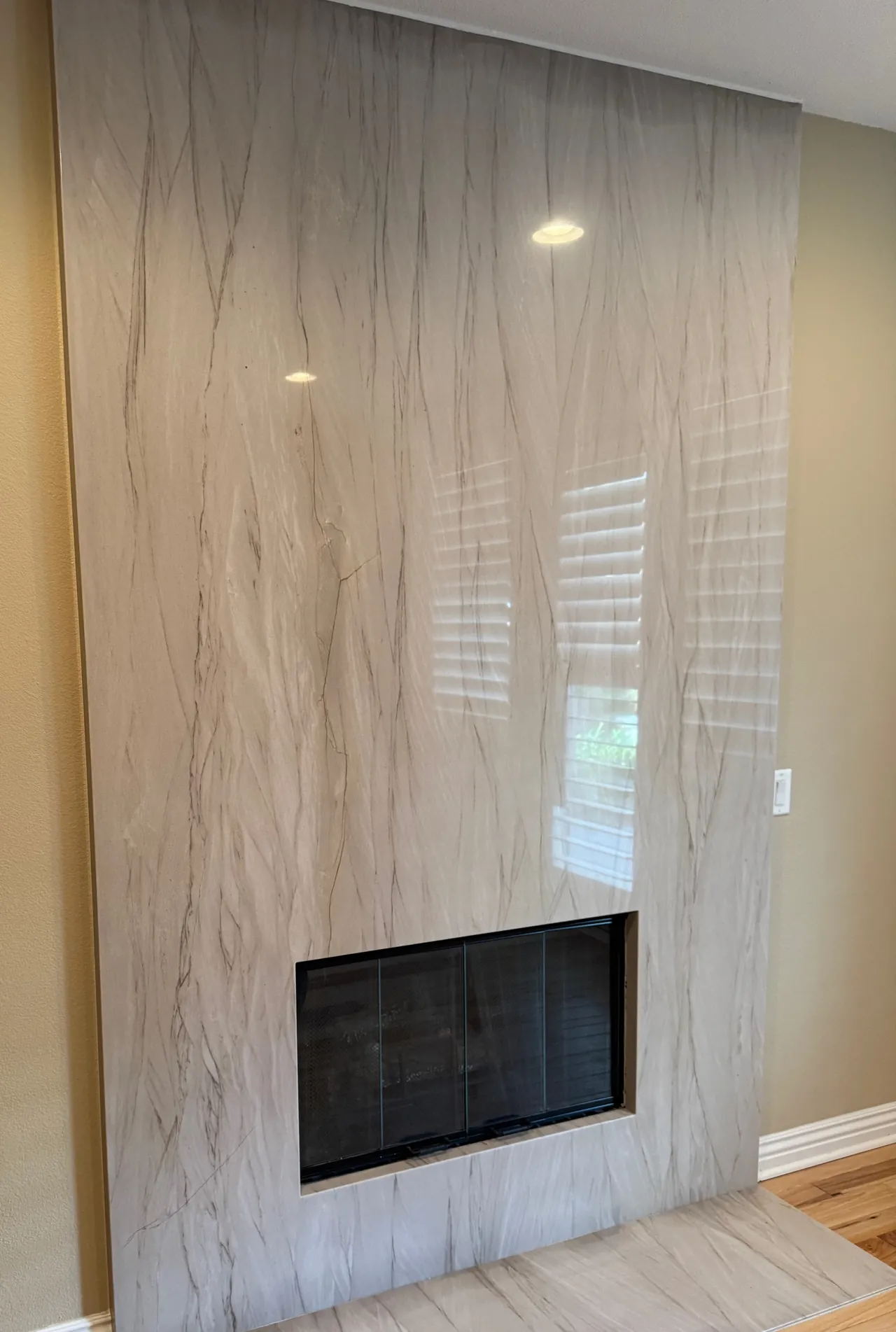 Floor-to-ceiling quartzite slab fireplace surround and hearth, seen from a three-quarter angle