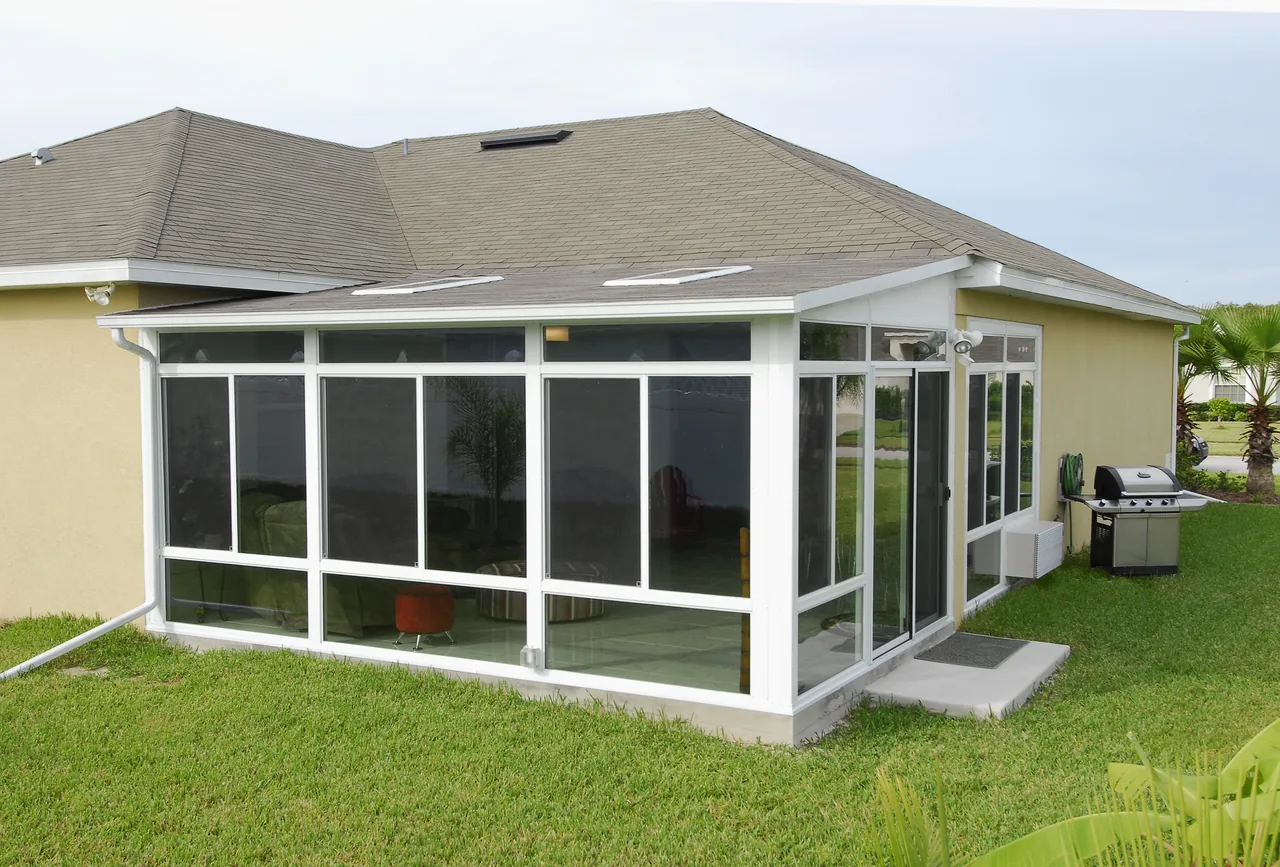 Four Seasons solid roof sunroom on the back of a single-story home