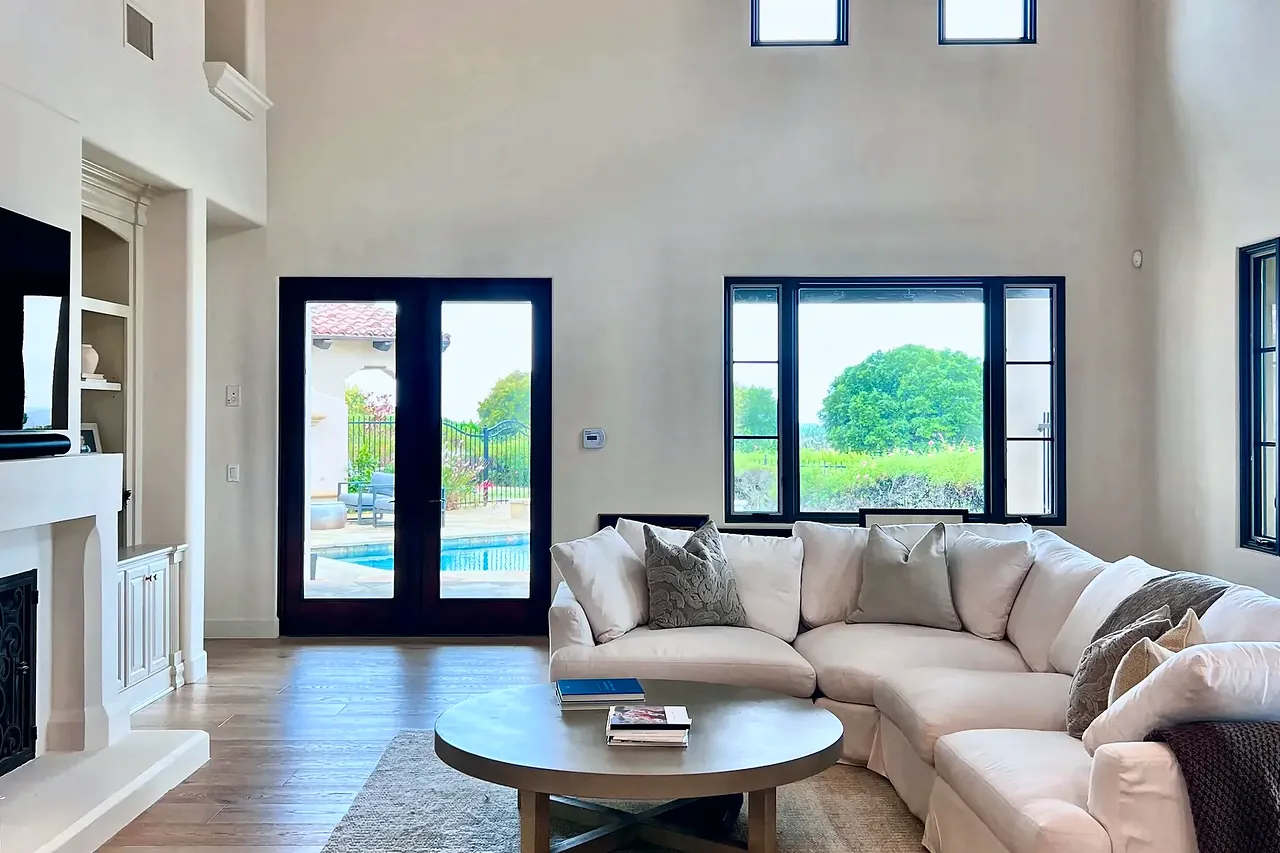 Living room with tall windows and French doors to the pool in a Santaluz whole-home remodel