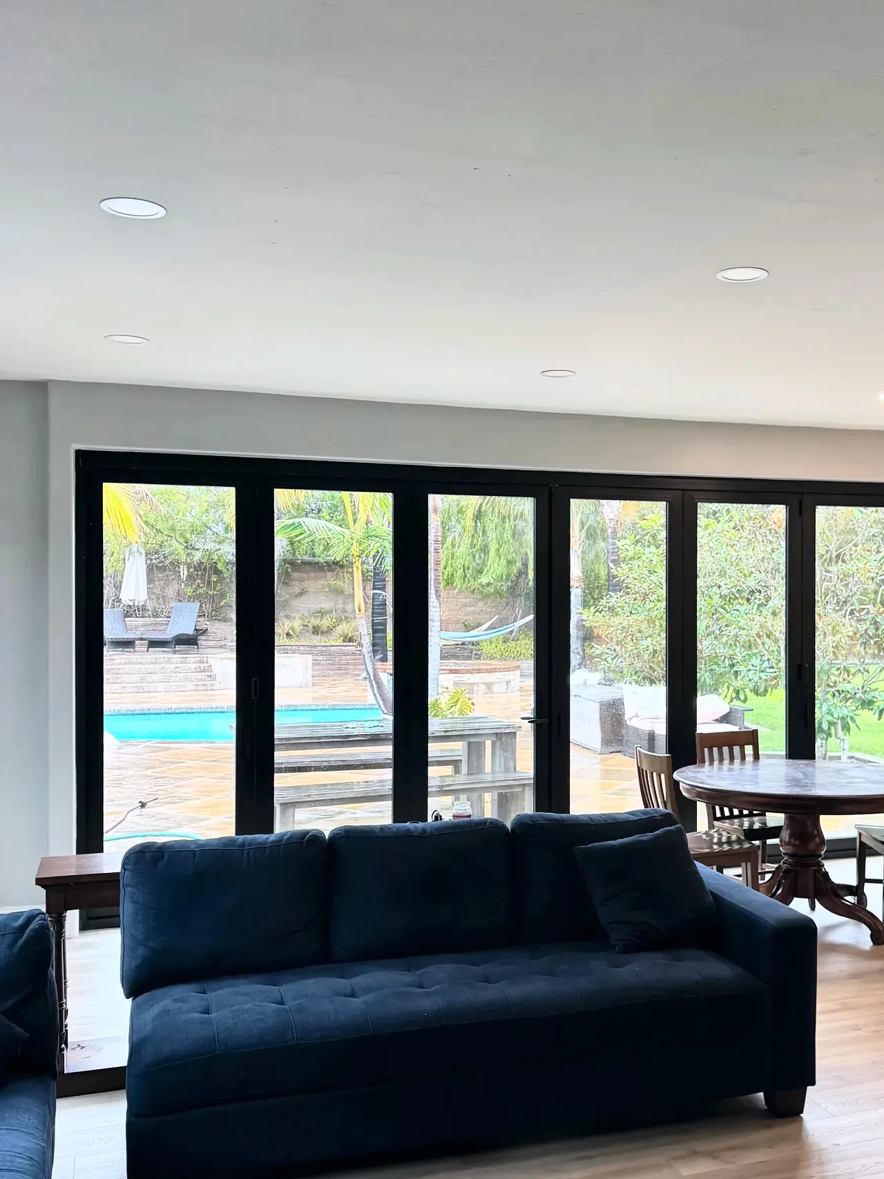 Black bifold door opening the family room to the patio and pool