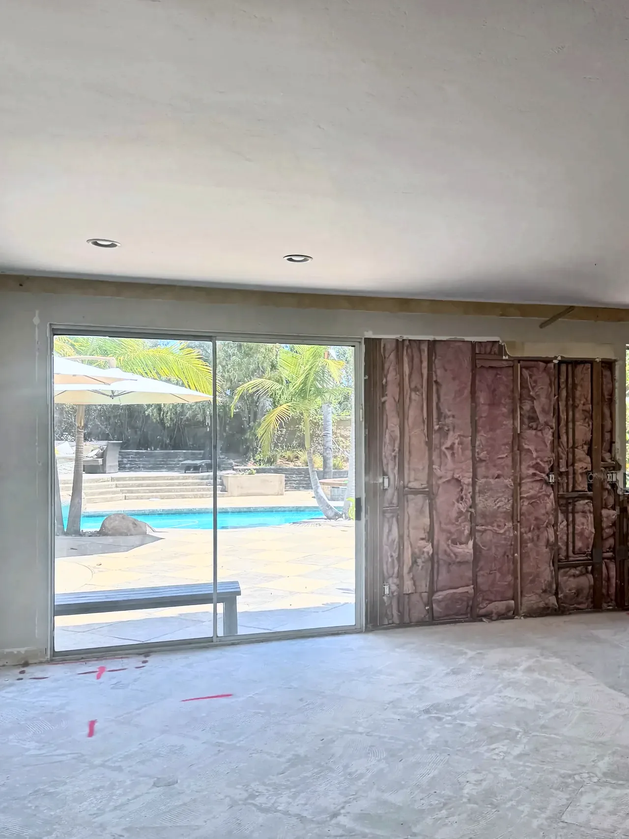 The family room wall before, with an old sliding door and the wall opened to the studs