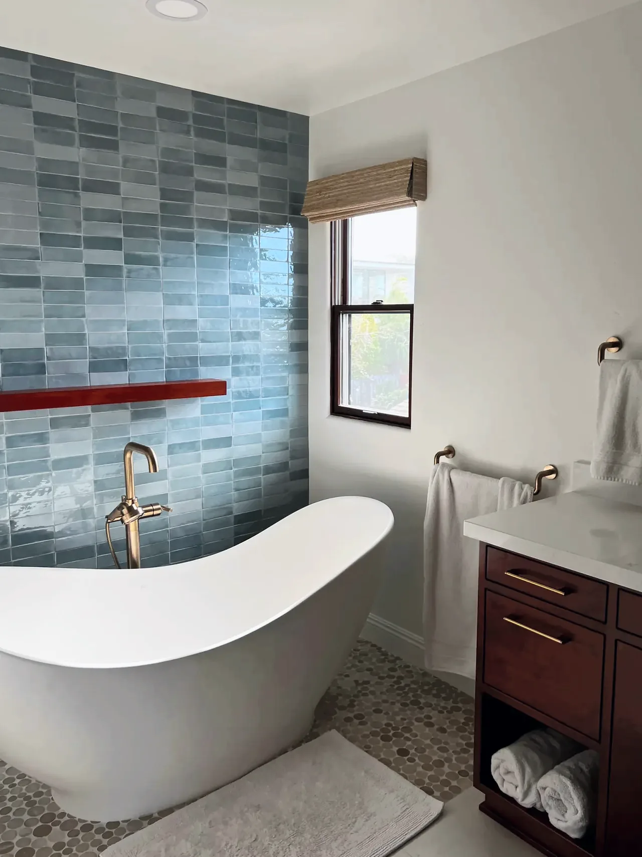 Slipper tub corner where the blue tile accent wall meets the white wall