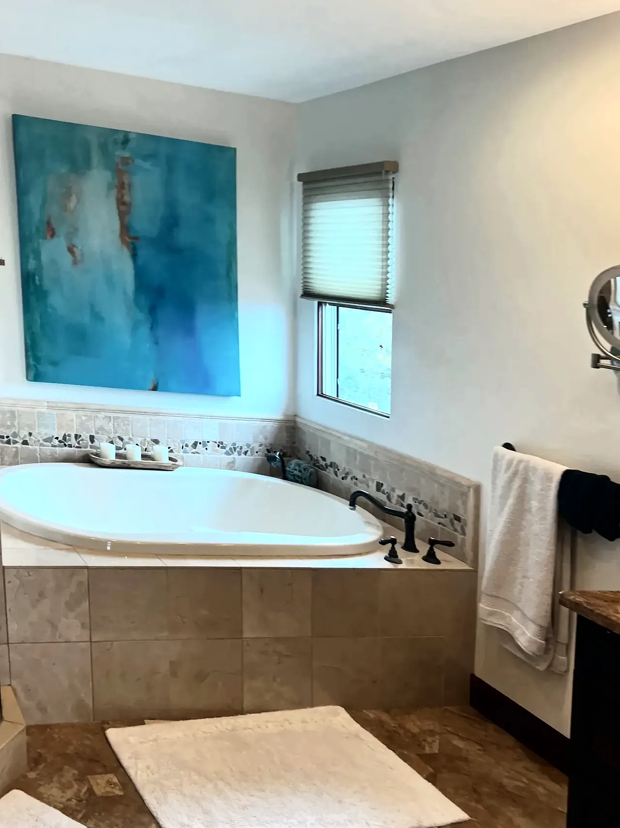 Primary bathroom before the remodel, with a drop-in tub in beige tile