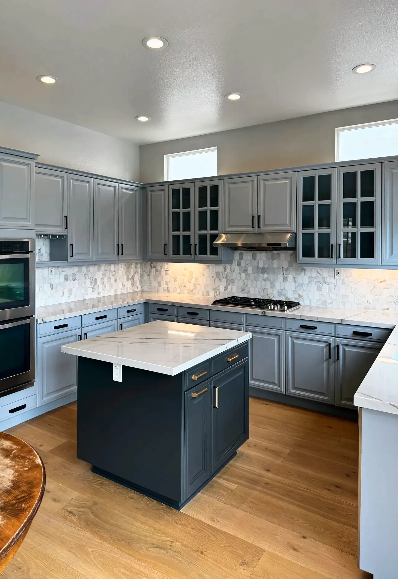 Carmel Valley kitchen with painted gray cabinets, a charcoal island, quartzite counters and a marble hexagon backsplash