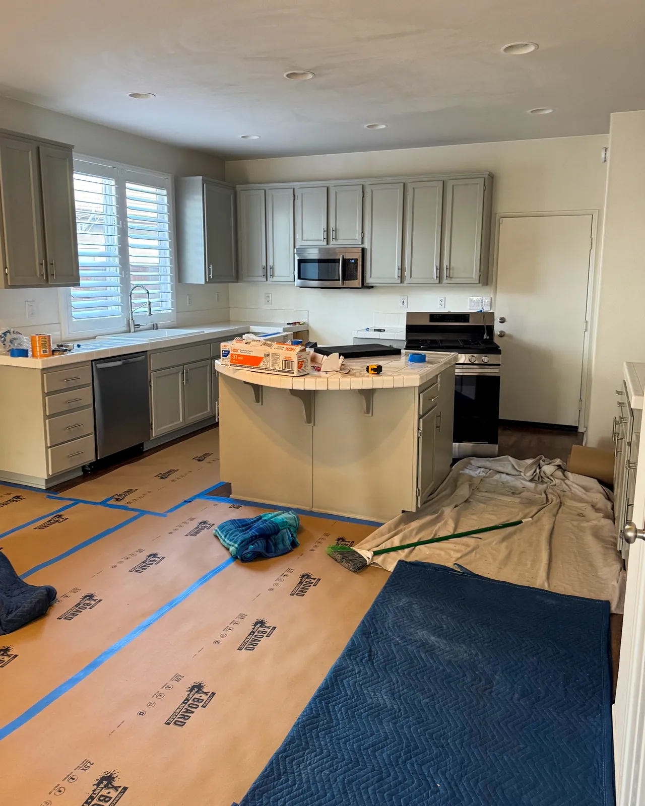 The kitchen before the remodel, with gray cabinets and a tiled island