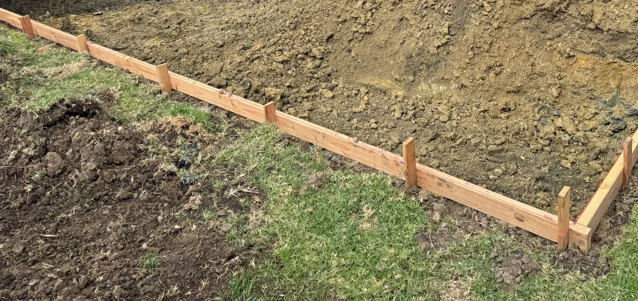 The pool dug out, with wood forms set along its edge