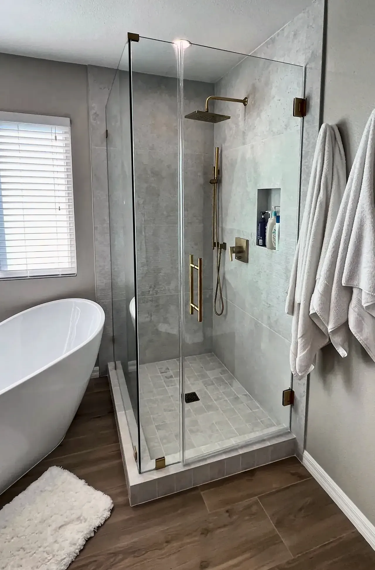 Frameless glass shower with a brass rain head