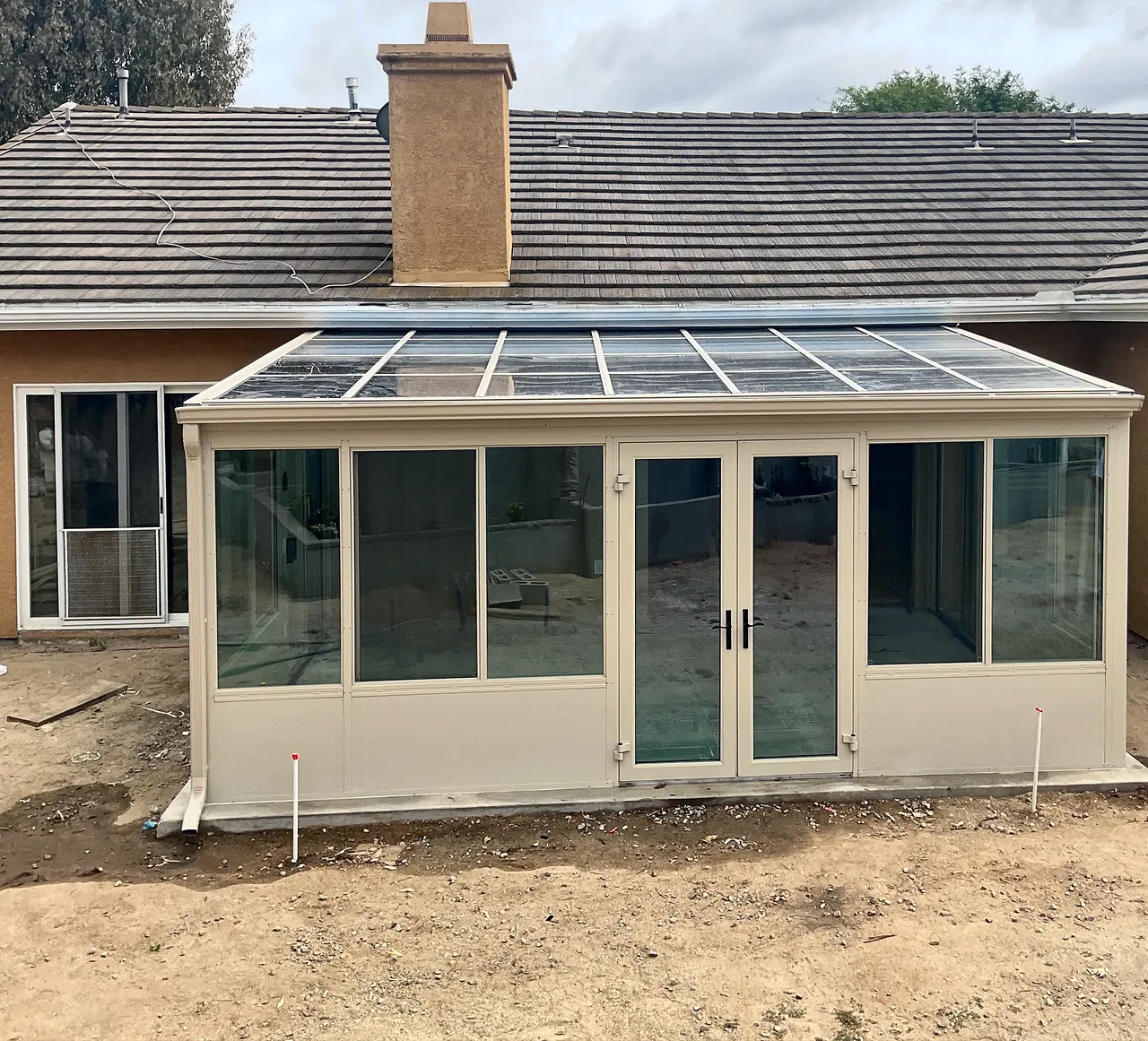 The finished sunroom in Fallbrook from the yard, with its glass roof, French doors and sliding windows