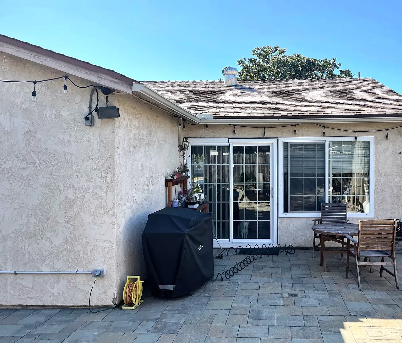 The back patio before the sunroom, in the inside corner where the back wall of the house meets the side of the wing
