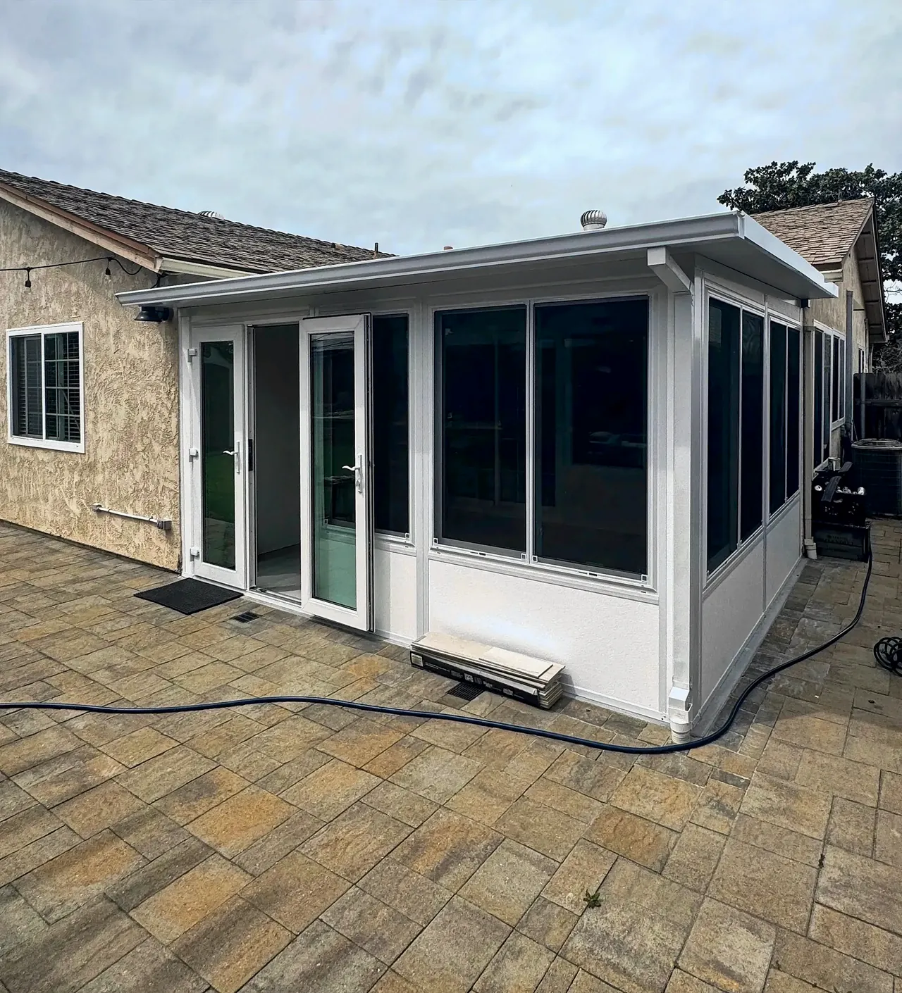 The finished sunroom in Mira Mesa, filling the inside corner at the back of the house, with windows along the side yard
