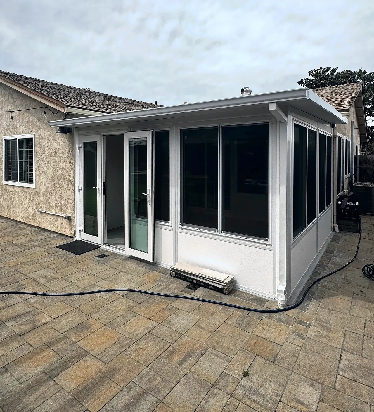 The finished sunroom in Mira Mesa, filling the inside corner at the back of the house, with windows along the side yard