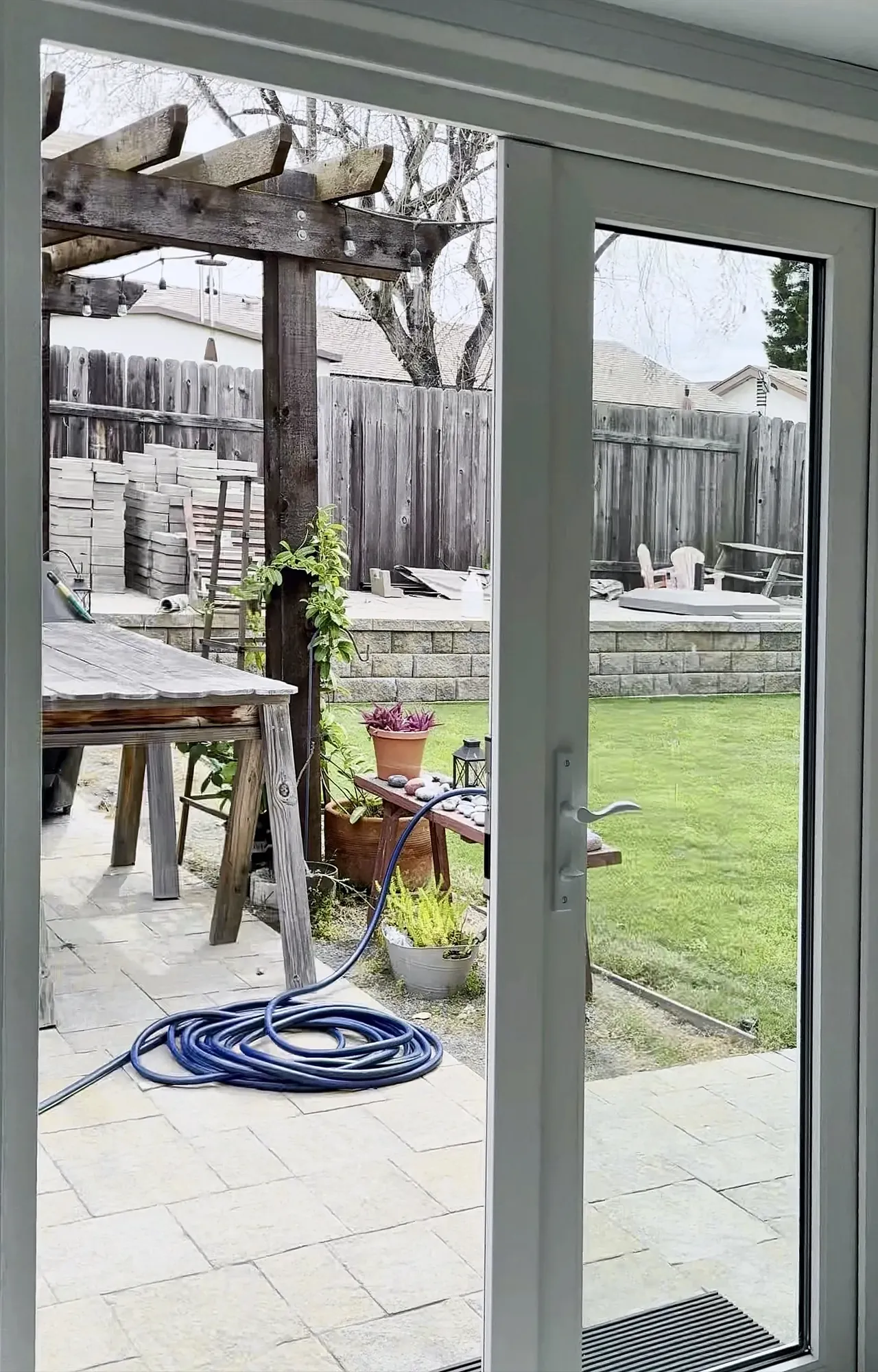 The glass French doors in the finished sunroom, one side open to the back patio and the lawn