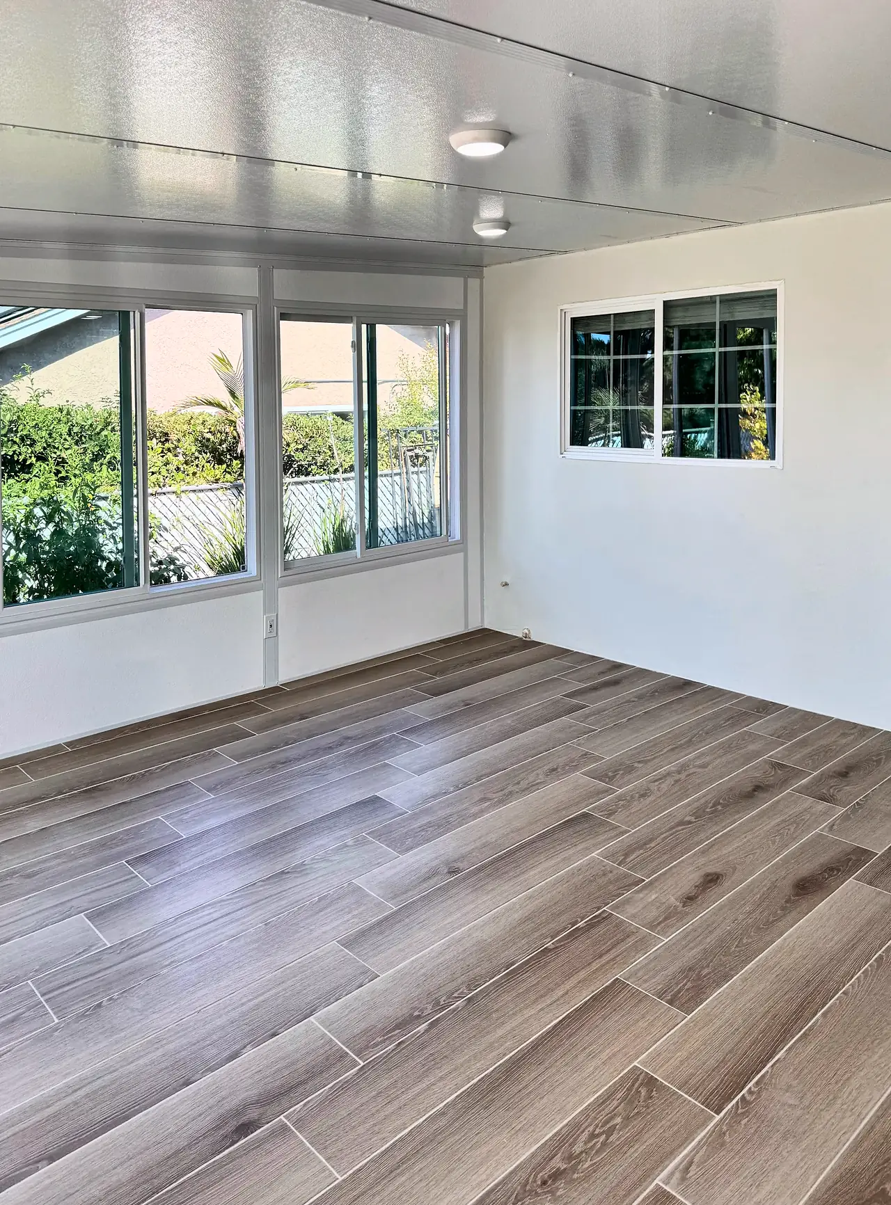 The old outside wall of the house, now inside the sunroom, plastered smooth and painted white around the original window